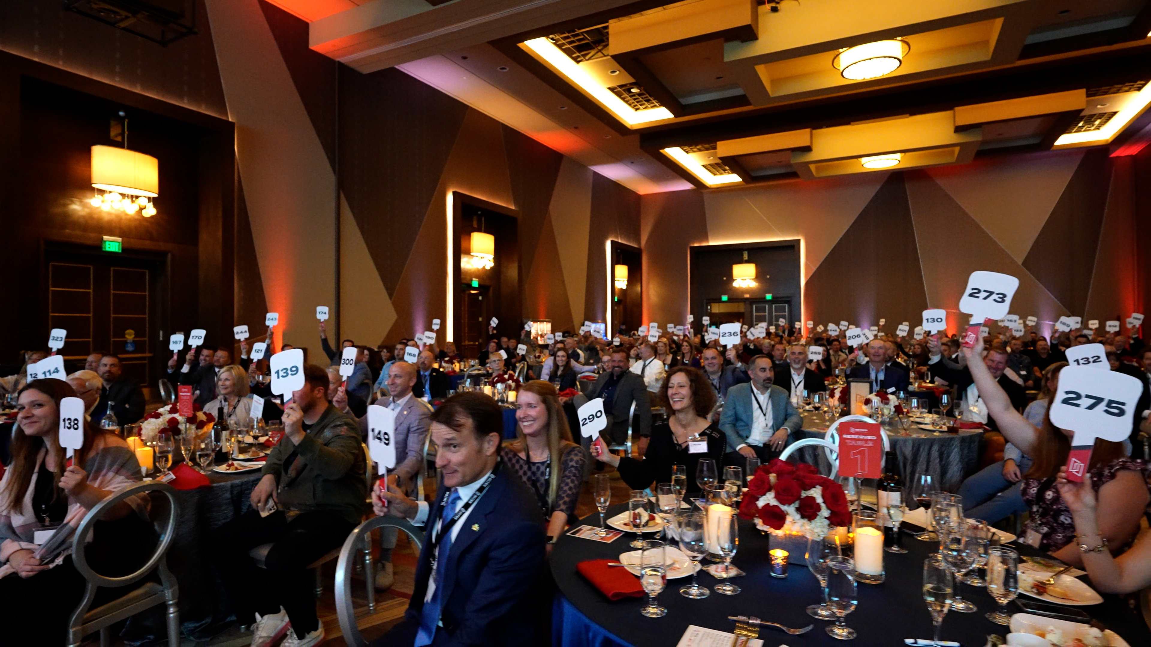 Prospective bidders hold up their paddles during the MITER Foundation’s live auction at its charity event in Temecula