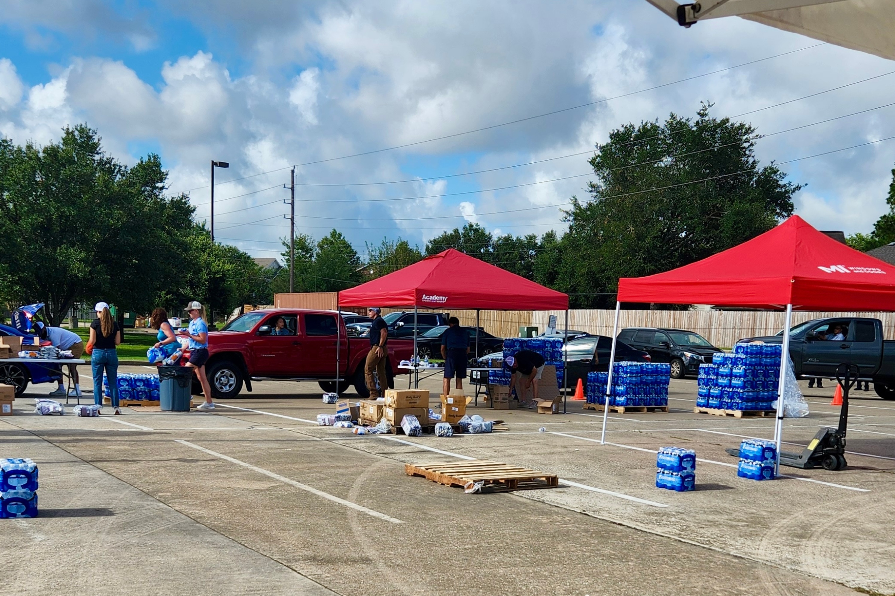 Volunteers load supplies into vehicles during MITER Brands’ drive-thru hurricane relief supplies distribution event.