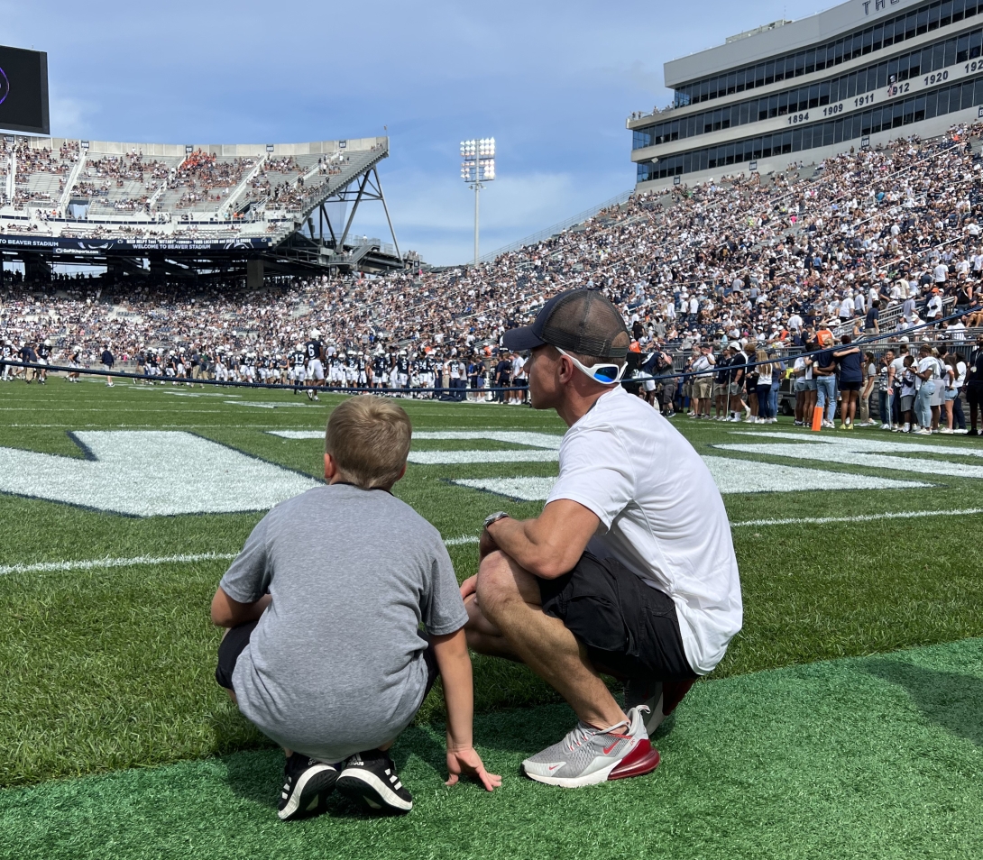 A Four Diamonds "Kick-Off Kid" prepares to retrieve the tee after a Penn State Football opening kickoff.